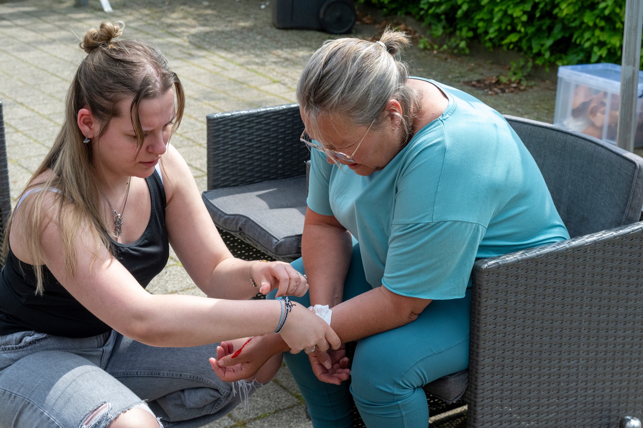 Deelnemers oefenen samen wondverzorging tijdens een EHBO-bijscholing