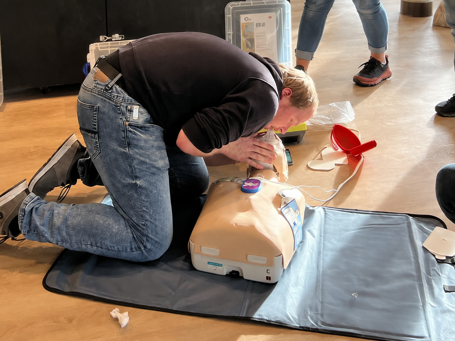 Deelnemer oefent beademing op een reanimatiepop tijdens een EHBO-praktijktraining