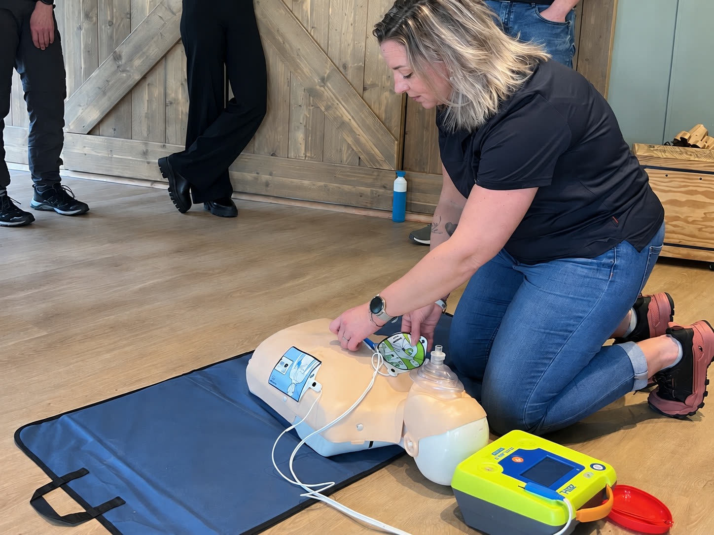 Instructrice demonstreert het gebruik van een AED bij een reanimatiepop